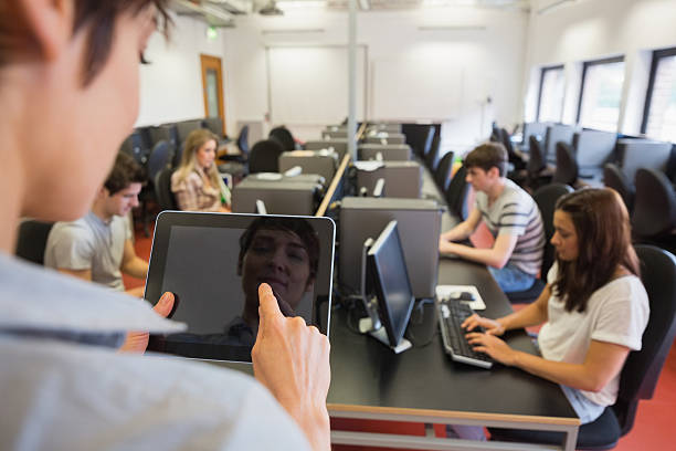 Woman teaching her computer class while holding a tablet pc